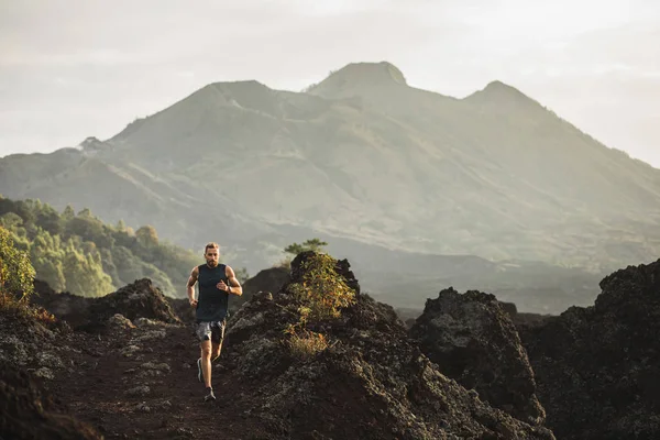 Young athlete man trail running in mountains in the morning. Ama — Stock Photo, Image