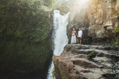 Genç ve hamile bir çift, Tegenungan C manzarasına bayılıyorlar.