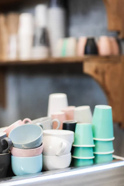 Heap of different blue, pink, white and green cups on coffee mac — Stock Photo, Image