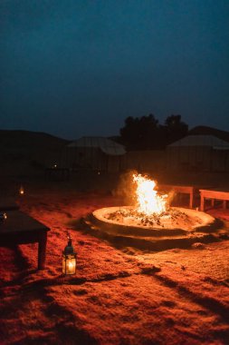 Sahra, Fas 'ta büyük bir kamp ateşiyle büyüleyici bir çöl kampında romantik bir akşam..