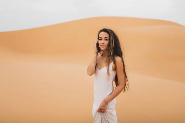 モロッコのサハラ砂漠の砂丘で若い美しい女性のかなりの肖像画 長い髪 東部の外観を持つブレット 白い絹のドレスの花嫁 — ストック写真