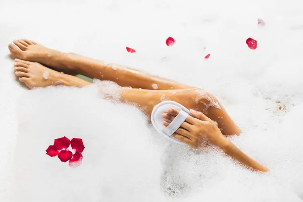 女人在浴缸里用泡沫泡洗脚 用天然的丝绒海绵 温泉治疗 身体护理 浪漫心情 — 图库照片