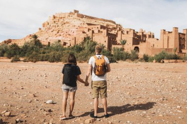 Ouarzazate 'de arka planda iki gezgin Ait Ben Haddou ksar. Fas 'a hoş geldiniz. Seyahat konsepti. Popüler dönüm noktası.