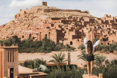 Popüler şehir simgesi Ait-Ben-Haddou 'nun tadını çıkaran bir kadın. Arkadan bak. Fas 'a git, Ouarzazate. Seyahat tutkusu konsepti.