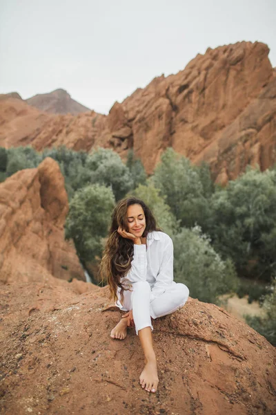 白い座ってモロッコのトドラ峡谷の景色を楽しむ美しいブルネットの女性 自然との調和と自由の概念 旅行生活 — ストック写真