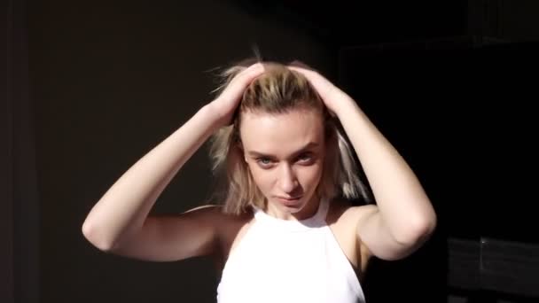 Fashionabla kvinna blondin poserar med hår på svart bakgrund — Stockvideo