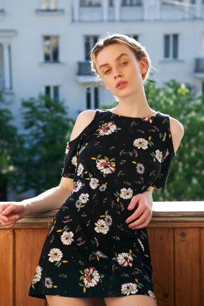 Blonde woman in a dress with flowers on the street — Stock Photo, Image