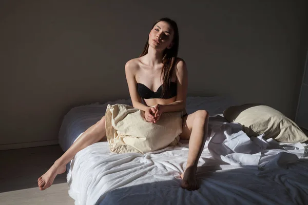 Morena mujer después de dormir en almohadas dormitorio en la cama —  Fotos de Stock