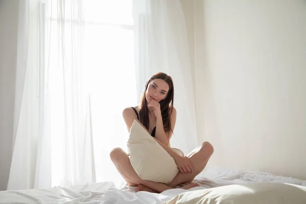 寝室の枕、ベッドの上で寝た後のブルネットの女性 — ストック写真