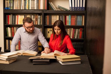 bir erkek ve bir kadın okumak kütüphanede kitap sınavı 1 için hazırlanıyorlar