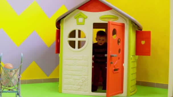 Маленький мальчик играет на детской площадке с игрушками — стоковое видео