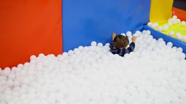 Le petit garçon jouant sur l'aire de jeux avec des balles — Video