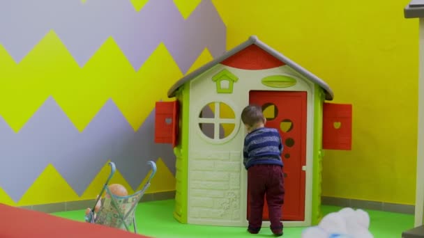 Der kleine Junge spielt auf dem Spielplatz mit Spielzeug — Stockvideo