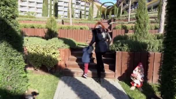 Mère et jeune fils marchent dans le parc dans la rue — Video