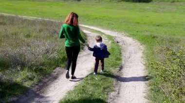 Anne ve genç oğlu ormandaki yolda gitmek