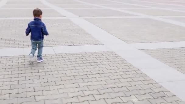 Un niño pequeño corriendo alrededor de la carretera corre — Vídeos de Stock