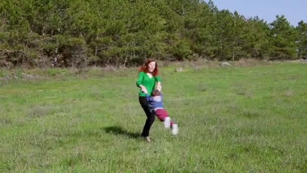 Mom plays with her son, and is spinning on the field — Stock Video