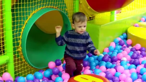 O menino brincando no playground com bolas — Vídeo de Stock