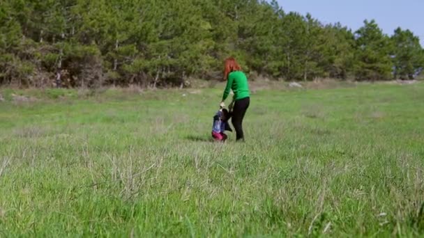 Mãe brinca com seu filho, e está girando no campo — Vídeo de Stock
