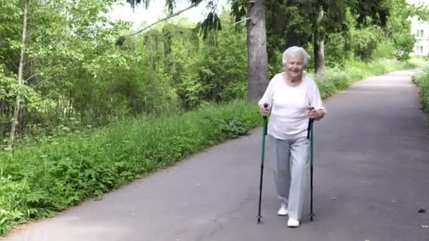 Großmutter geht mit Nordic-Walking-Stöcken alt grau — Stockvideo