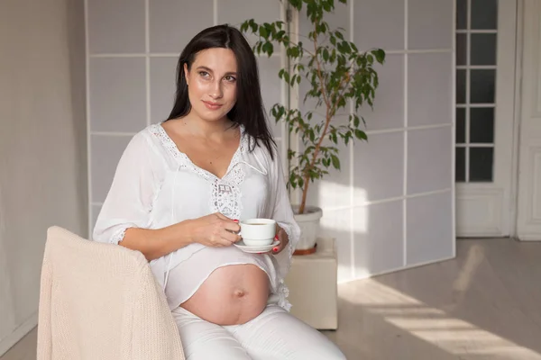 Vacker gravid kvinna i ett vitt rum — Stockfoto