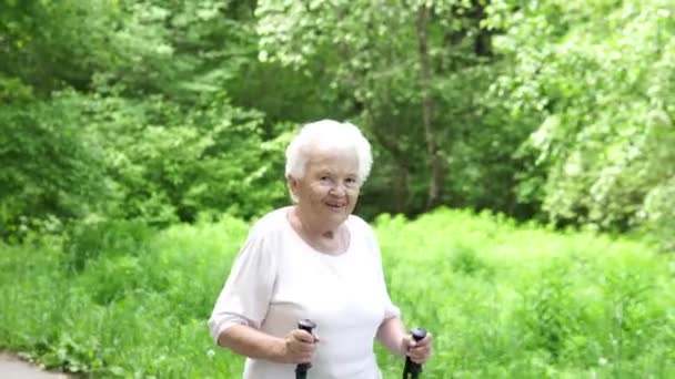 Nonna cammina con bastoni da nordic walking vecchi grigi — Video Stock