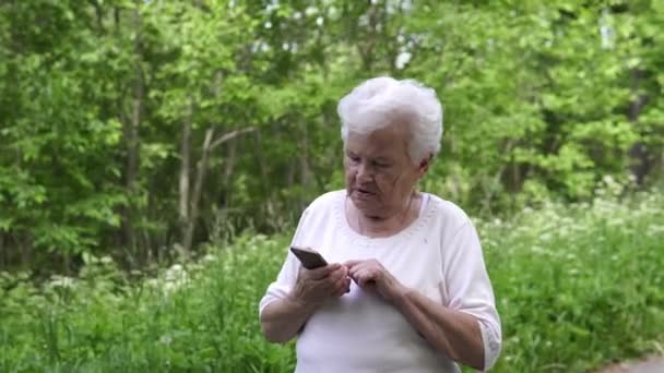 Fehér hajú Granny beszél a telefonon családjával — Stock videók