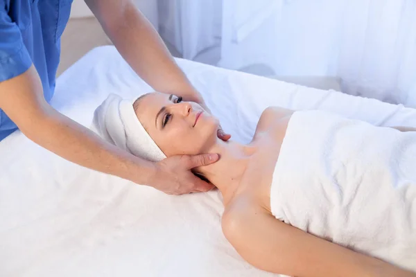 Жінка робить масаж обличчя і шиї лікування — стокове фото