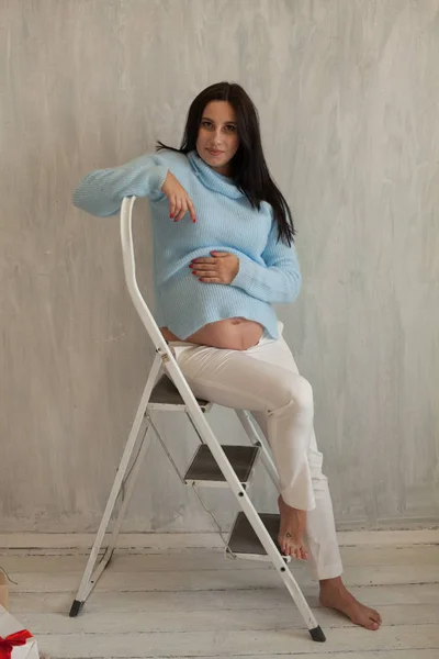 Portrait d'une femme enceinte dans la robe bleue murs gris — Photo