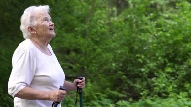 Abuela camina con bastones nórdicos gris viejo — Vídeo de stock