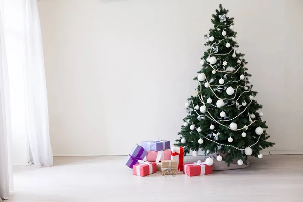 Kerstboom met giften van Kerstmis in witte kamer — Stockfoto