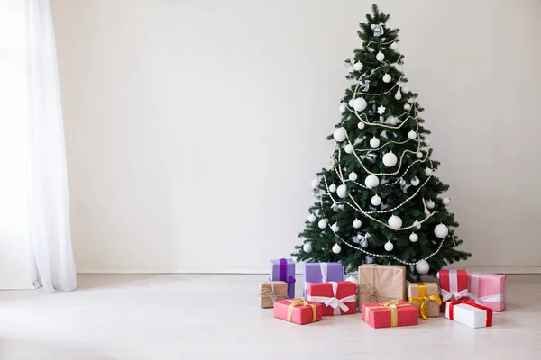 A karácsonyi ajándékokat, fehér szobában a karácsonyfa — Stock Fotó