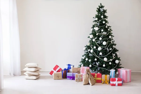 Weihnachtsbaum mit Weihnachtsgeschenken im weißen Raum — Stockfoto