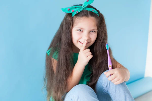 Bambina senza denti con uno spazzolino in odontoiatria — Foto Stock