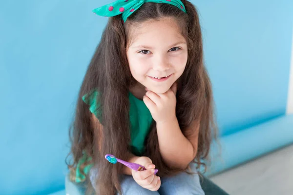 Bambina senza denti con uno spazzolino in odontoiatria — Foto Stock