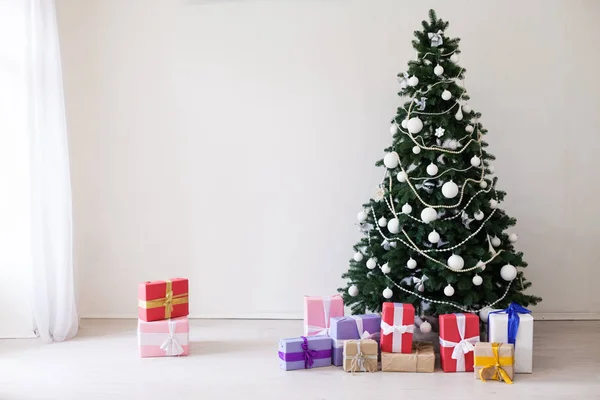 Christmas tree with Christmas gifts in white room — Stock Photo, Image