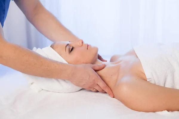 Vrouw doet medische massage van het gezicht en de hals in Spa — Stockfoto