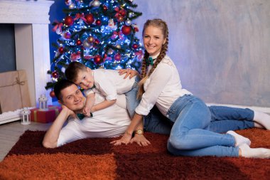 Anne baba ve küçük bir çocuk yeni yıl için Noel hediyeleri açmak