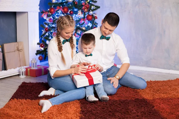 Mom dad and a little boy open Christmas gifts for the new year — Stock Photo, Image