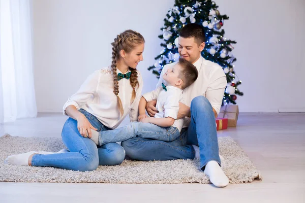 Maman papa et un petit garçon décorent le sapin de Noël en hiver — Photo