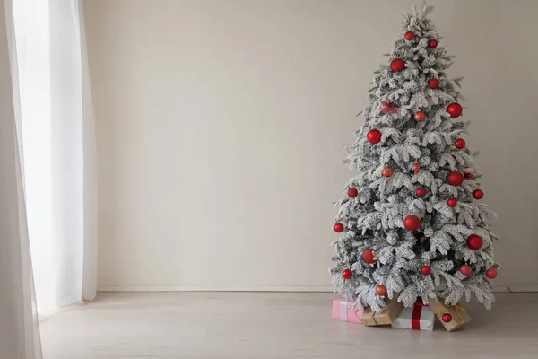 Árbol de Navidad en una habitación blanca con regalos en invierno —  Fotos de Stock