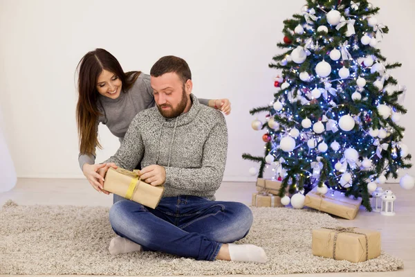 Man och hustru jul julgran med gåvor — Stockfoto