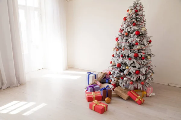 Jul julgran med presenter i ett vitt rum på vintern — Stockfoto