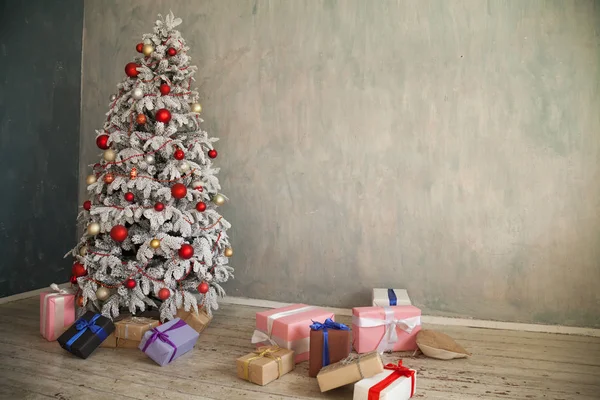 Χριστουγεννιάτικο χιονισμένο χριστουγεννιάτικο δέντρο με δώρα σε ένα λευκό δωμάτιο το χειμώνα — Φωτογραφία Αρχείου