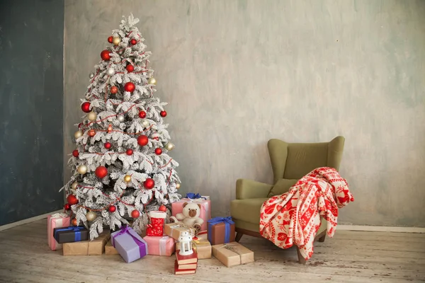 Árbol de Navidad nevado con regalos en una habitación blanca en invierno —  Fotos de Stock