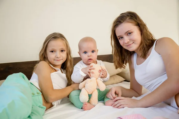 Tre flickor systrar i spela i sovrummet på morgonen älskar — Stockfoto