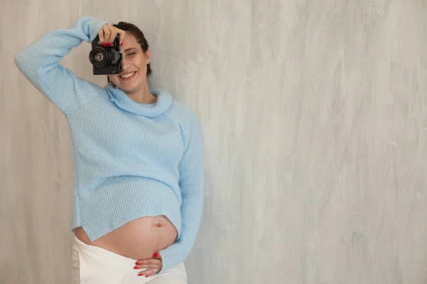 Портрет красивой беременной женщины-фотографа на фотосессии — стоковое фото