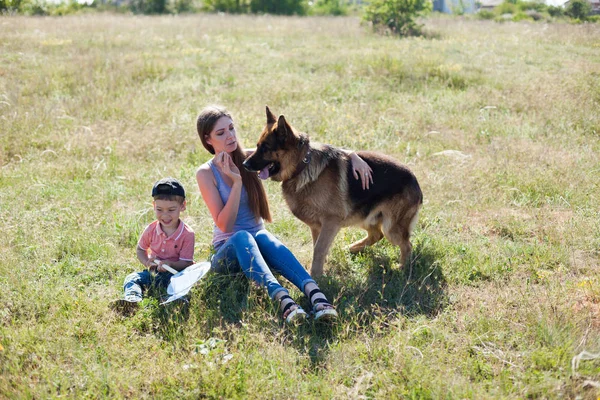 Matka i syn, grając z tresowany pies — Zdjęcie stockowe