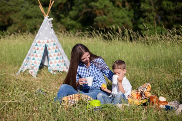 Mãe e filho jovem comem no piquenique viagem natureza — Fotografia de Stock