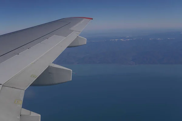 Vista al mar desde el ala del avión iljuminatora en viaje —  Fotos de Stock